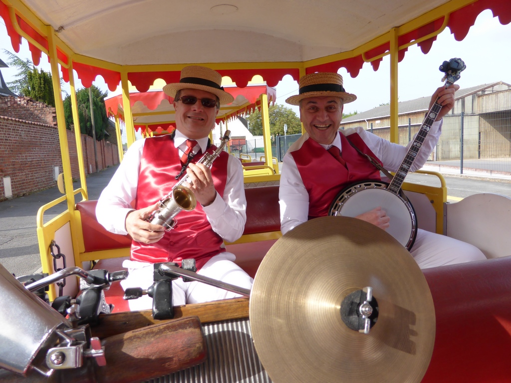 Les musiciens dans le petit train en route pour les aubades sur le trajet de la grande parade