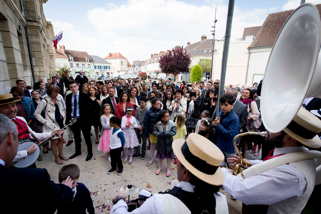 L'orchestre de jazz en quartet joue pour les mariés qui sortent de la mairie sous les applaudissements des invités