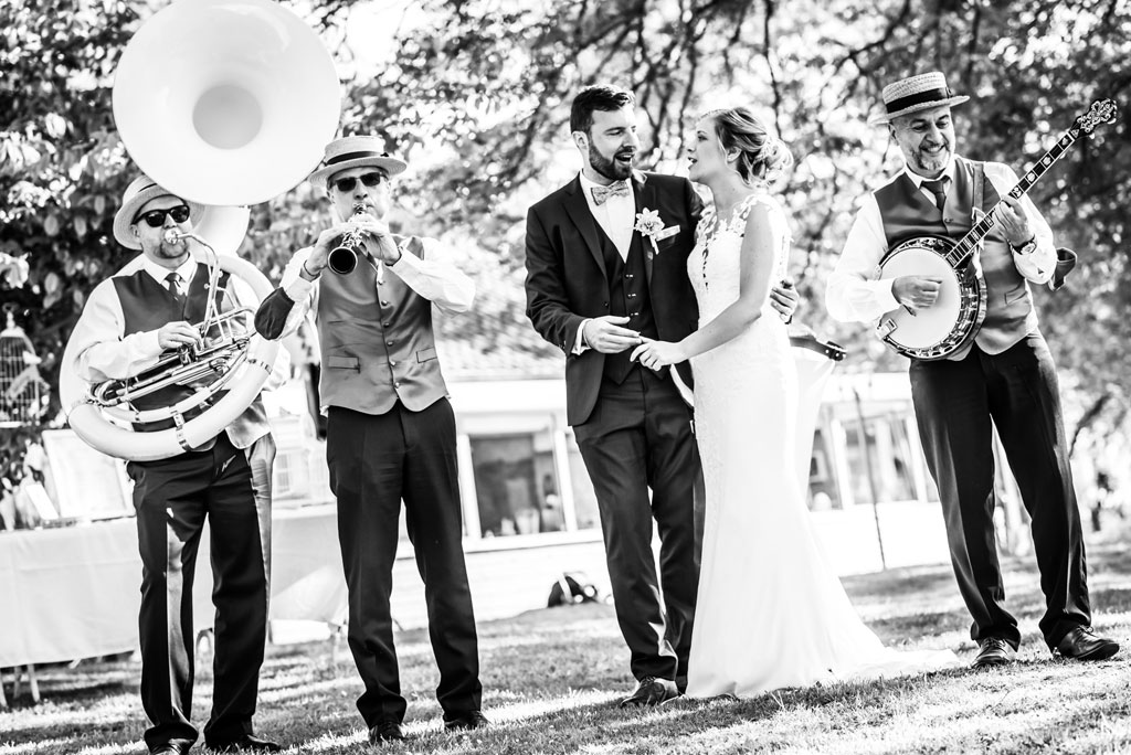 Le trio de jazz pose avec les mariés qui se tiennent par la main, se regardent et chantent.
